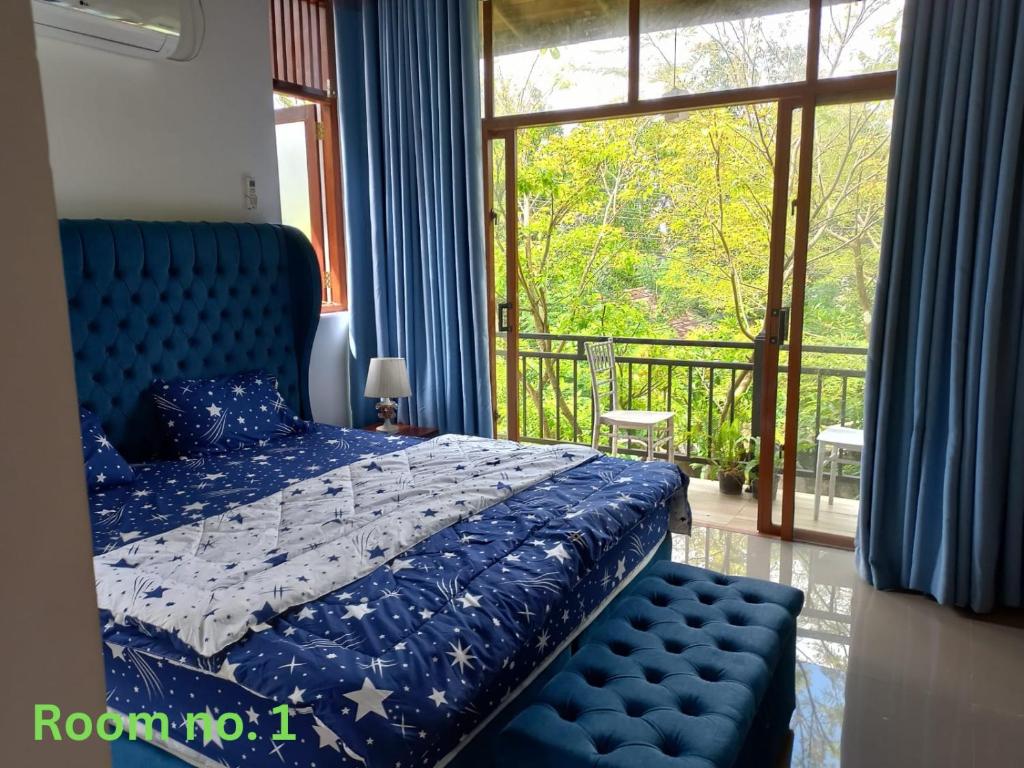 a bedroom with a blue bed and a balcony at Gampaha Heritage in Gampaha