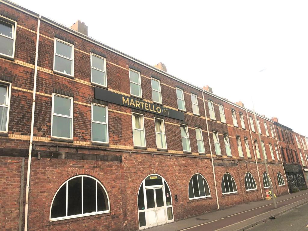 un edificio de ladrillo rojo con una señal de marcadotolon en él en Martello Hotel, en Hull