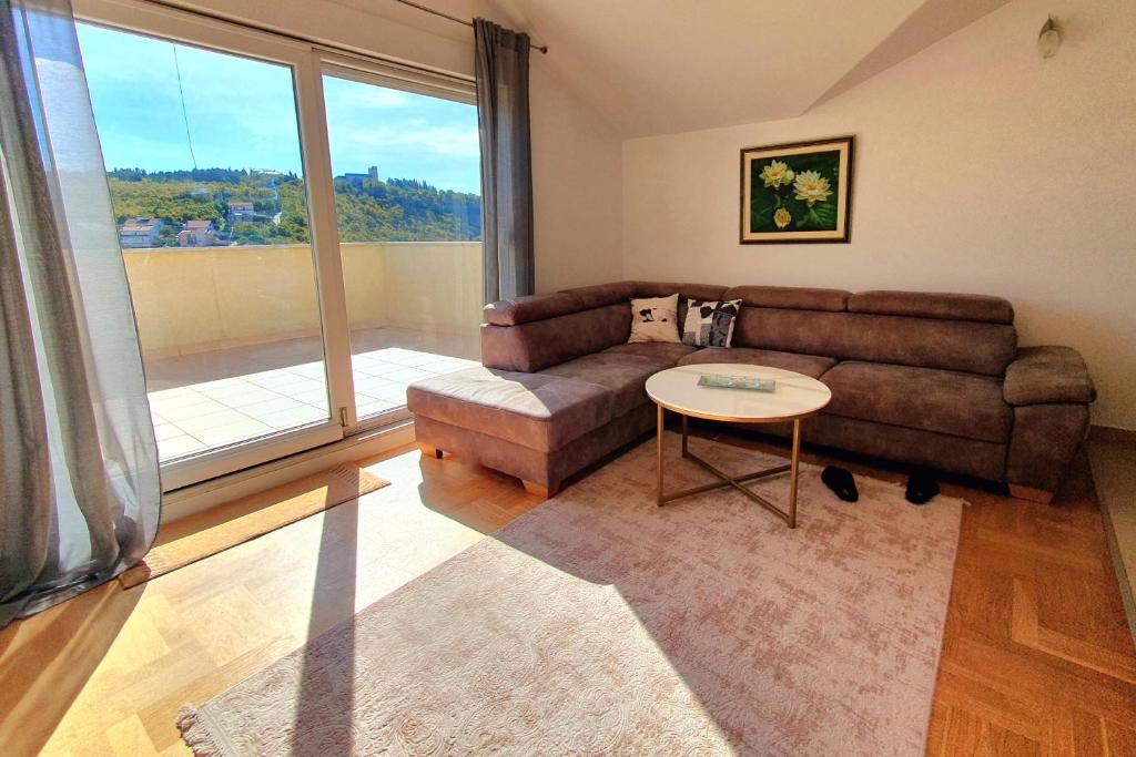 a living room with a couch and a table at Luxury Penthouse in Široki Brijeg