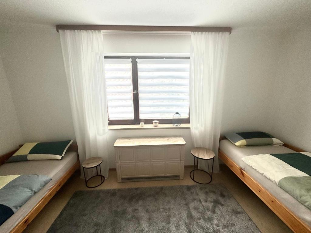 1 dormitorio con 2 camas individuales y ventana en Schönes, friedliches Zimmer, en Augsburg