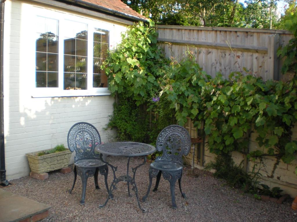 2 sillas y una mesa en un jardín en Hillside Cottage, en Ledbury