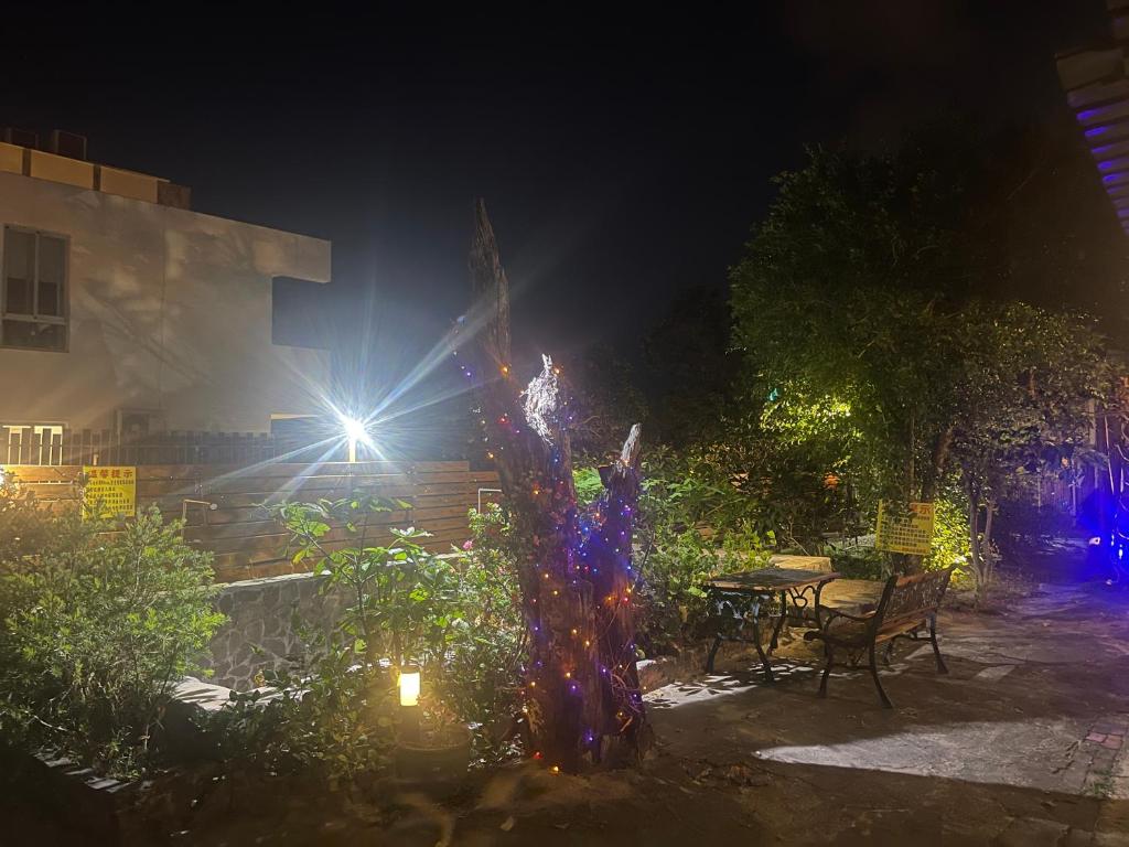 a garden at night with a table and lights at 寧靜的家14人Villa獨立設施包棟戲水池烤肉區麻將廚房私人停車場 in Hengchun South Gate