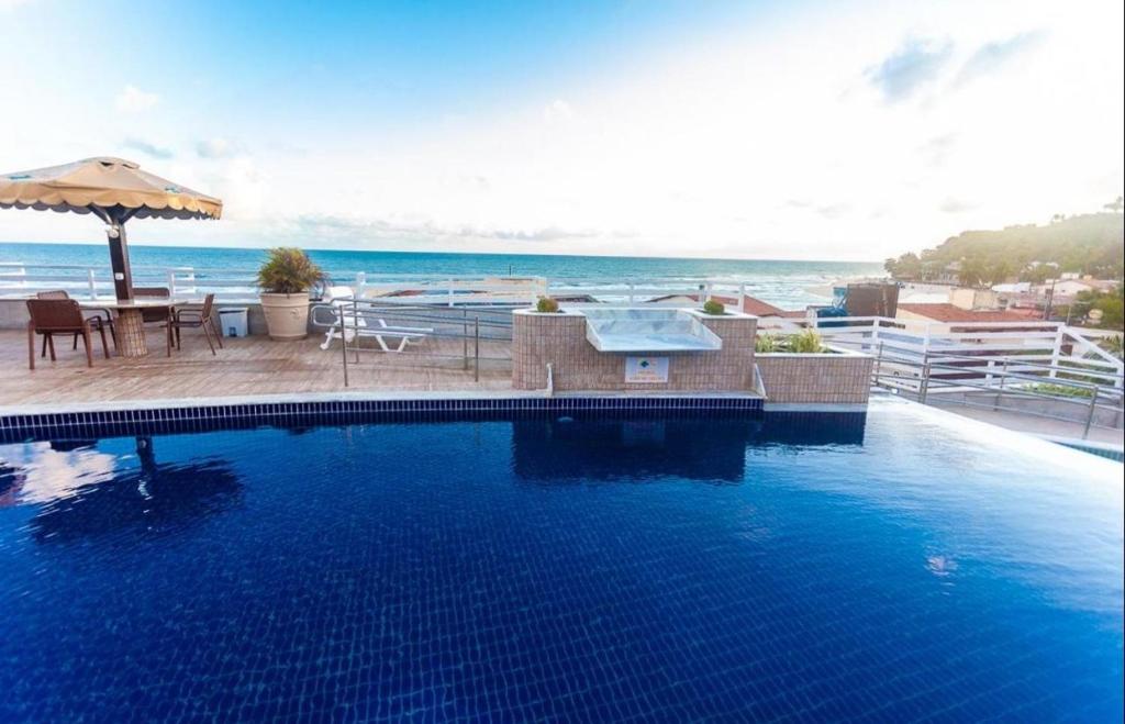 a swimming pool with a view of the ocean at FLAT PIPAS BAY 217 in Pipa