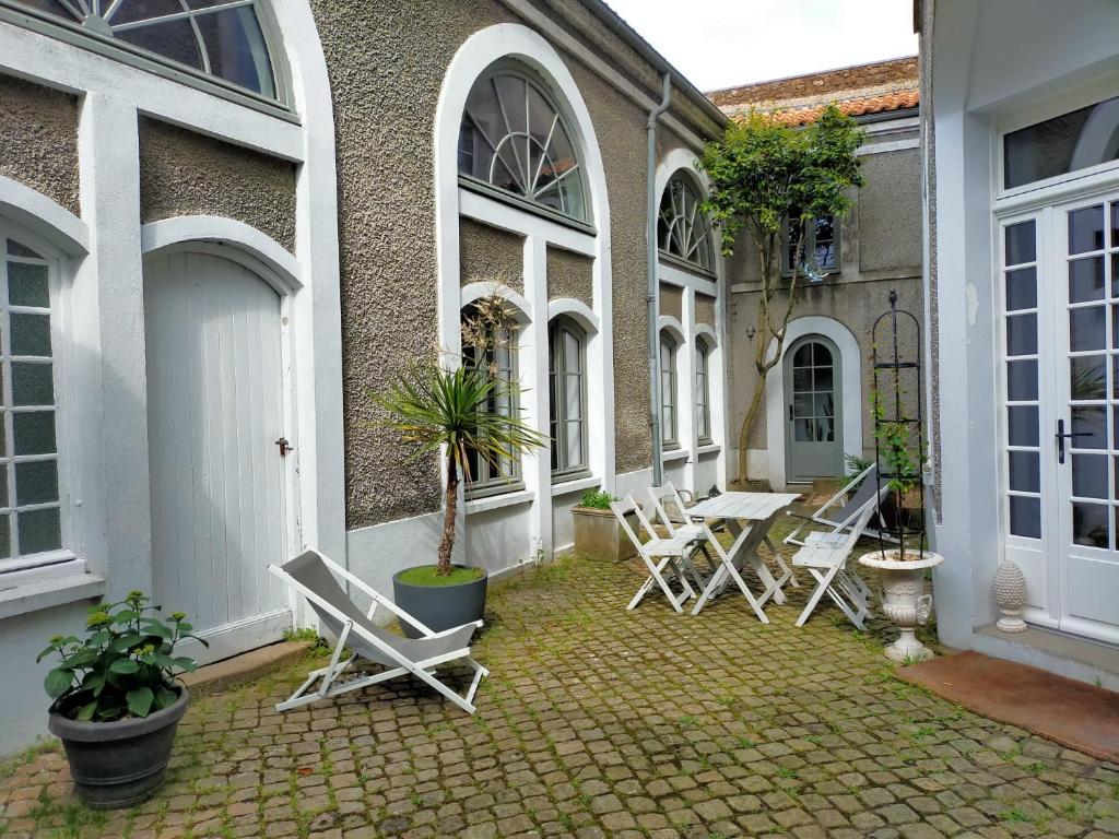 a patio with chairs and a table on a building at La Suite 14 in Cholet