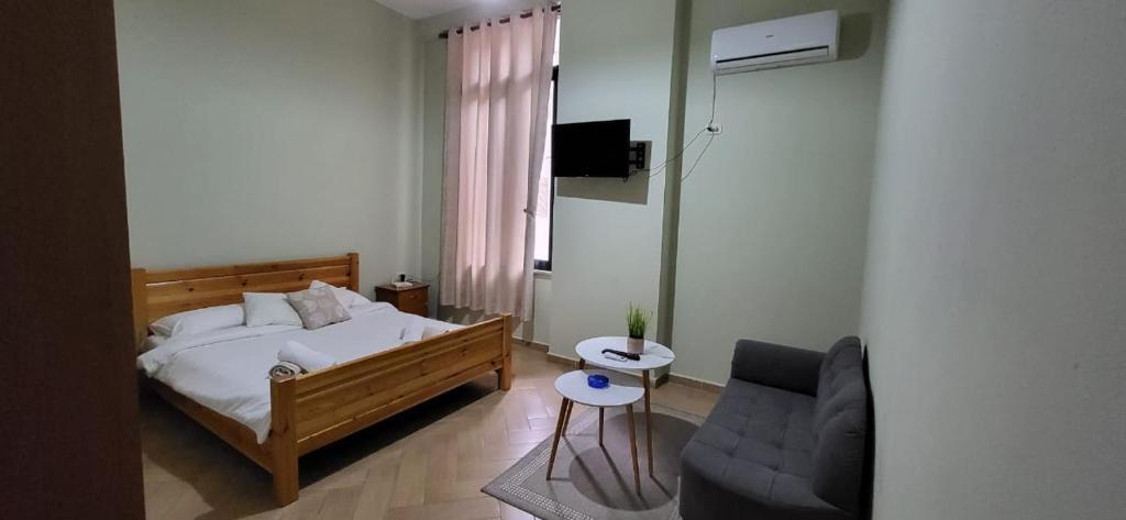 a bedroom with a bed and a couch at Agroni Rooms-21 in Tirana