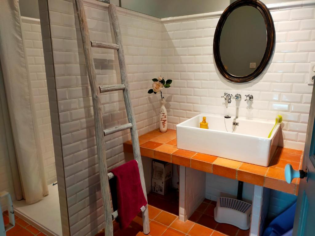 La salle de bains est pourvue d&#39;un lavabo et d&#39;un miroir. dans l&#39;établissement La Suite 14, à Cholet