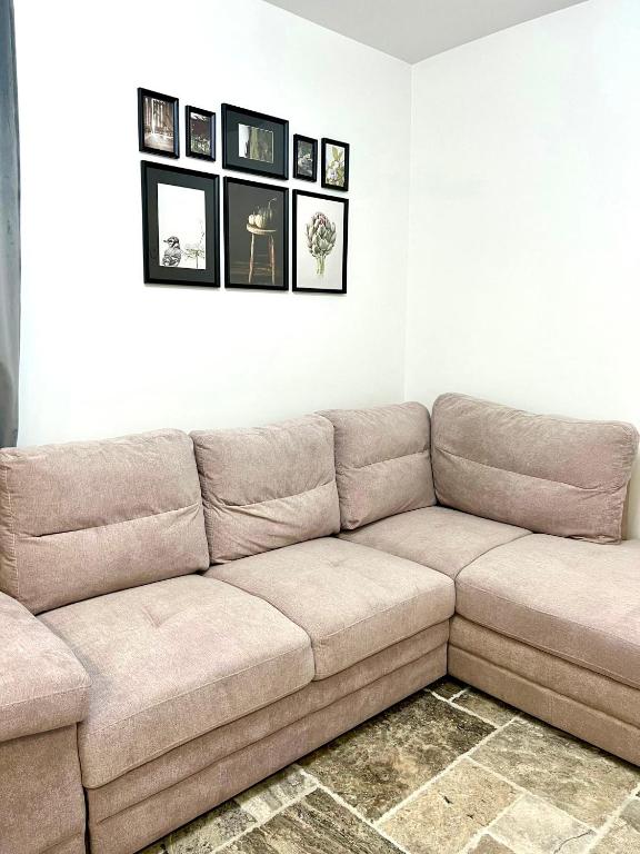 a brown couch in a living room with pictures on the wall at Titan Studio in Bucharest