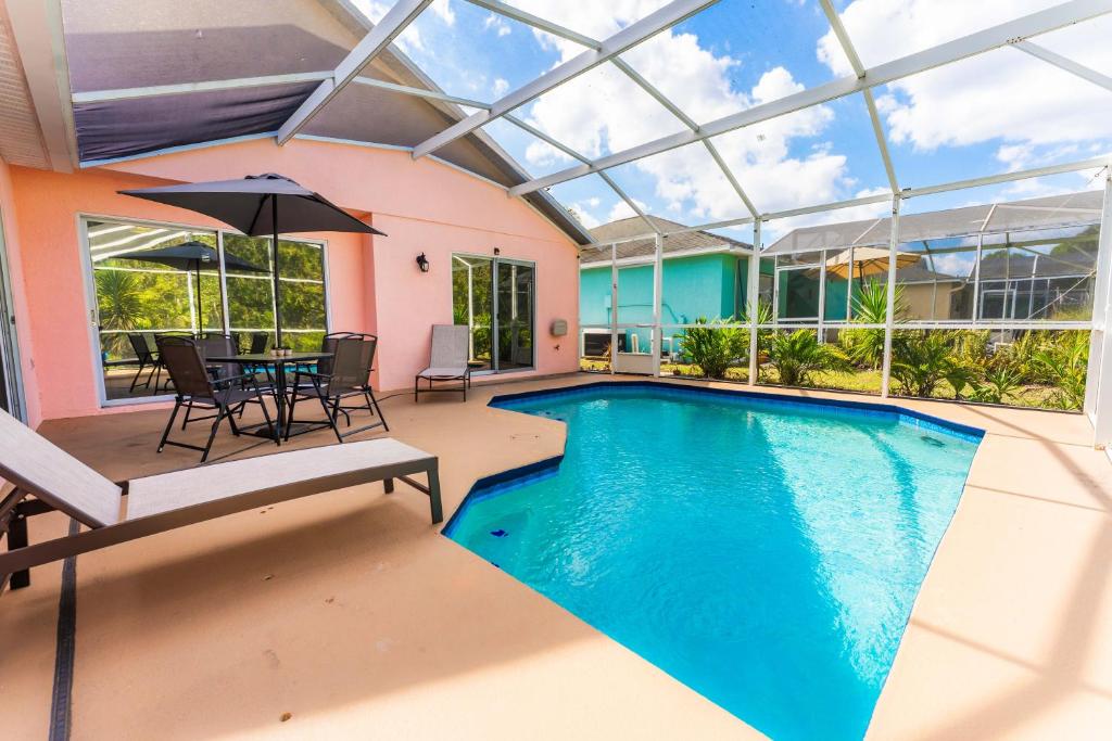 an indoor pool with a table and chairs and an umbrella at Home in davenport Cheerful 4-bedroom with pool in Davenport