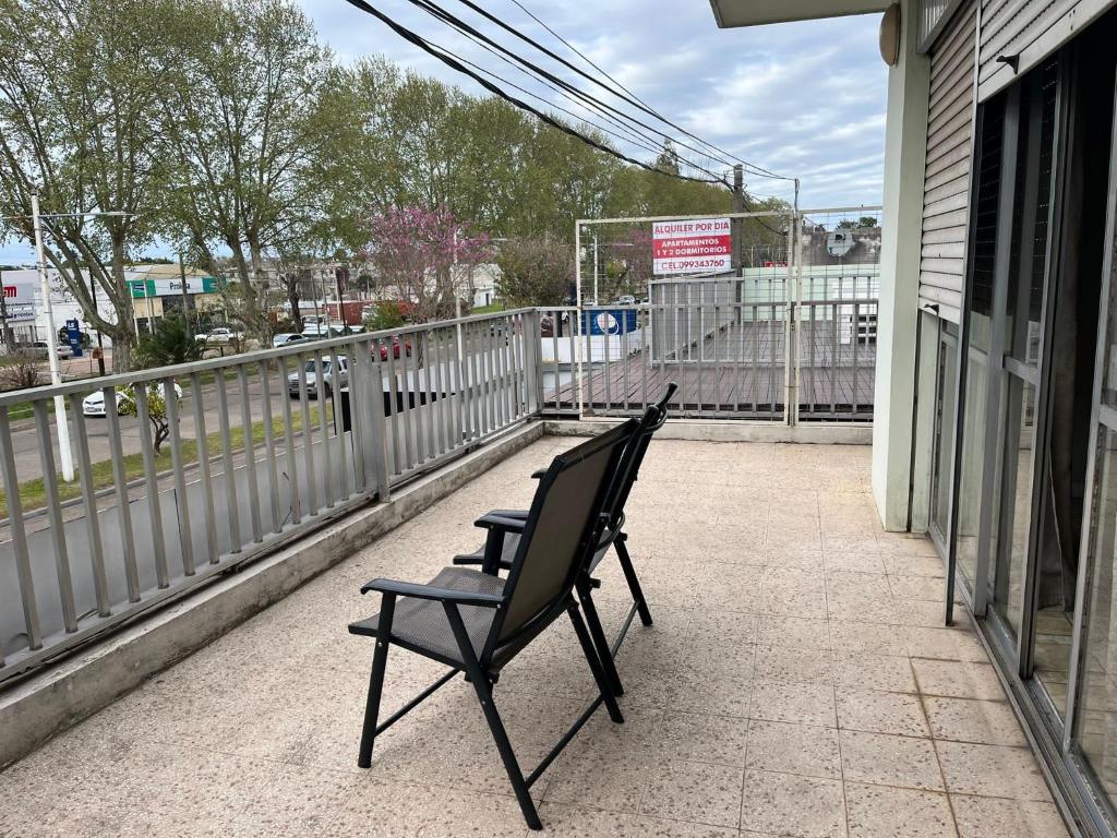 2 sedie nere sedute su un balcone con recinto di Relax V a Paysandú