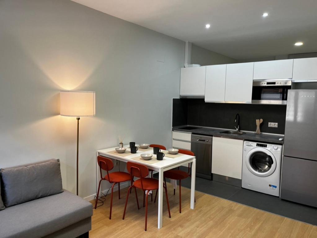 馬德里的住宿－Exyca Plaza Castilla，一间带桌椅的厨房和一间带洗衣机的厨房