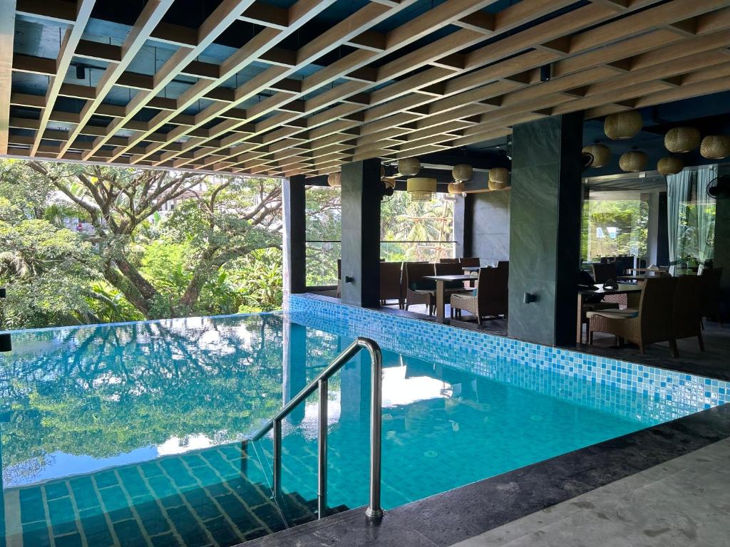 a pool in the middle of a building with a restaurant at Hotel Ami Grace in Port Blair
