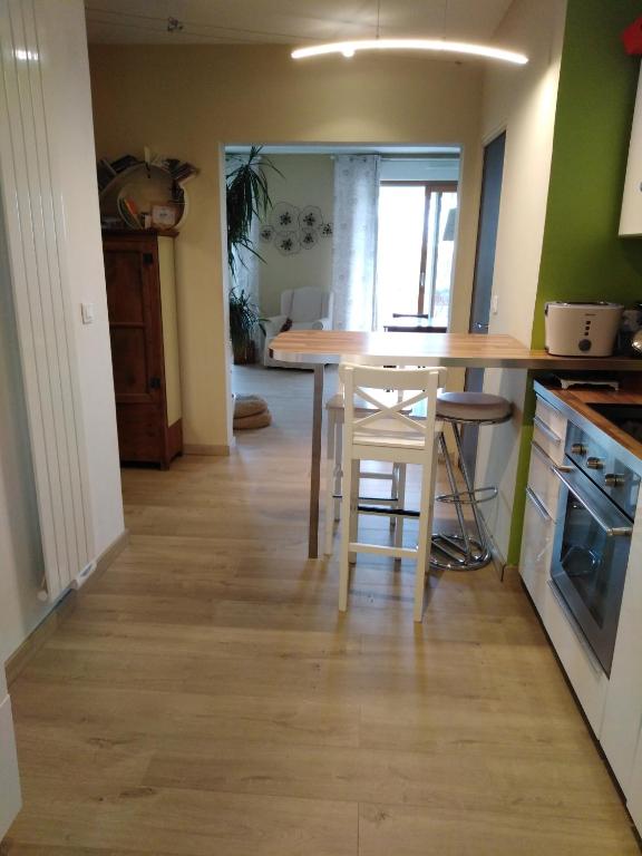 une cuisine avec un comptoir, une table et des chaises dans l'établissement Appartement confortable centre ville, à LʼIsle-sur-la-Sorgue
