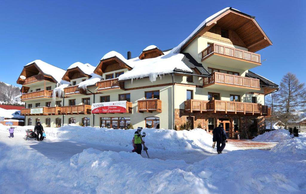 un rifugio da sci con persone in piedi sulla neve di Apartman TULANIE 58 Kamzik Donovaly 2 IZBOVY Mezonet Deluxe parkovanie v podzemnej garáži ZDARMA a Donovaly