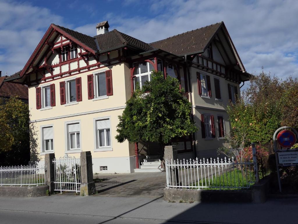 une maison blanche et noire avec une clôture dans l'établissement Historische Villa im Herzen Rankweils, à Rankweil