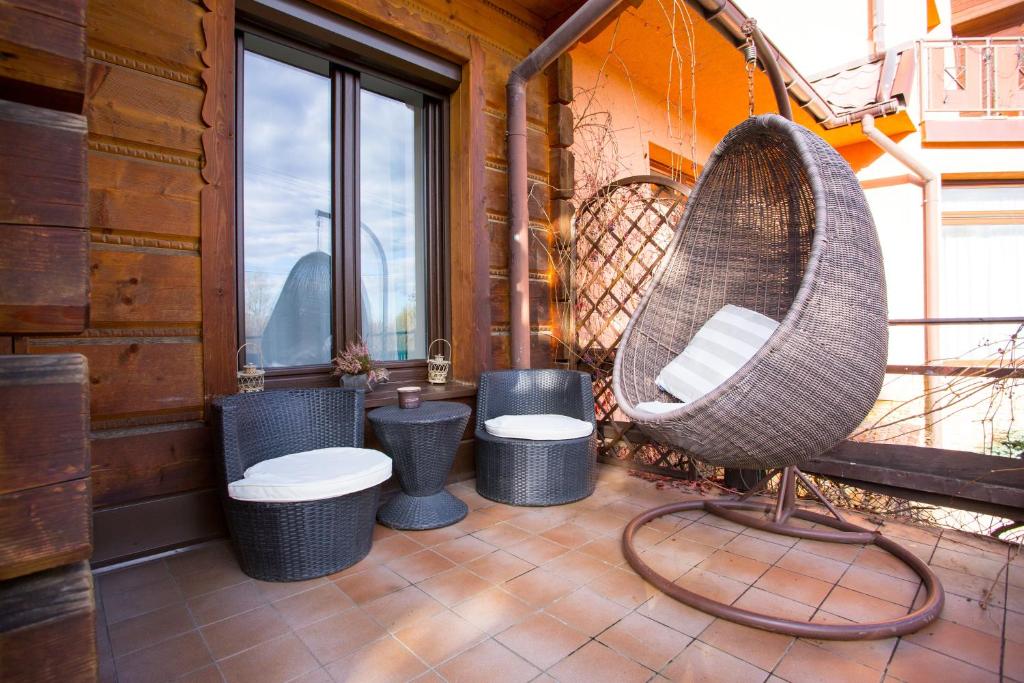 a porch with a rattan chair and three toilets at Chałupa u Kaśki in Nowy Targ