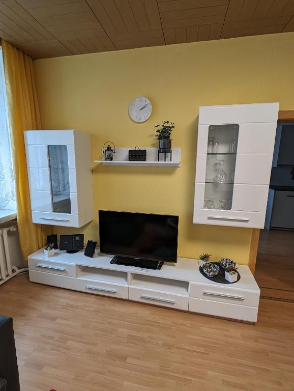 a living room with a tv on a white table at Ferienwohnung 1 in Schlettau