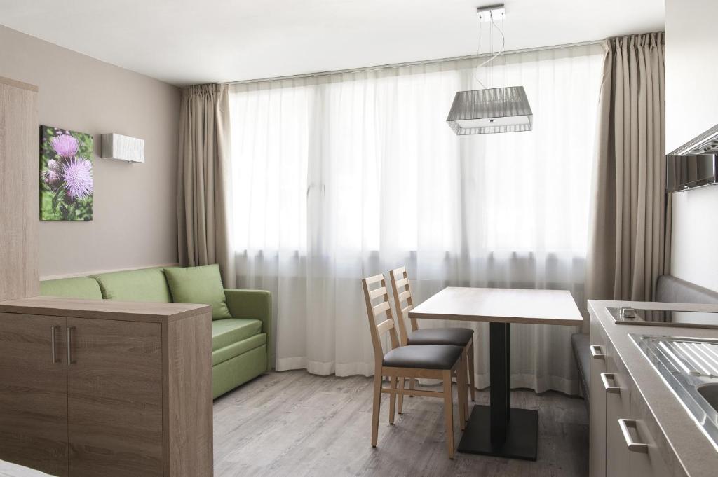 a kitchen and living room with a table and a couch at Appartamenti Pradalago Marilleva 900 in Marilleva