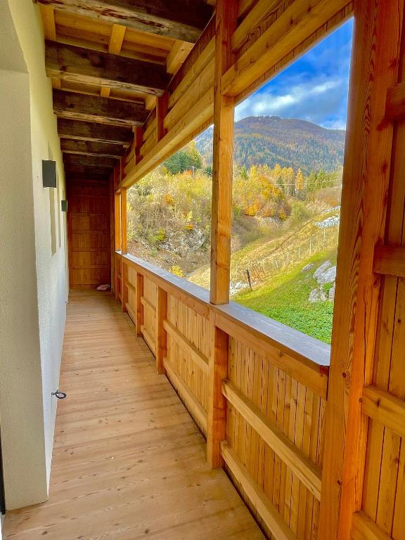 a hallway with a large window in a wooden cabin at Le Stue in Pieve di Cadore