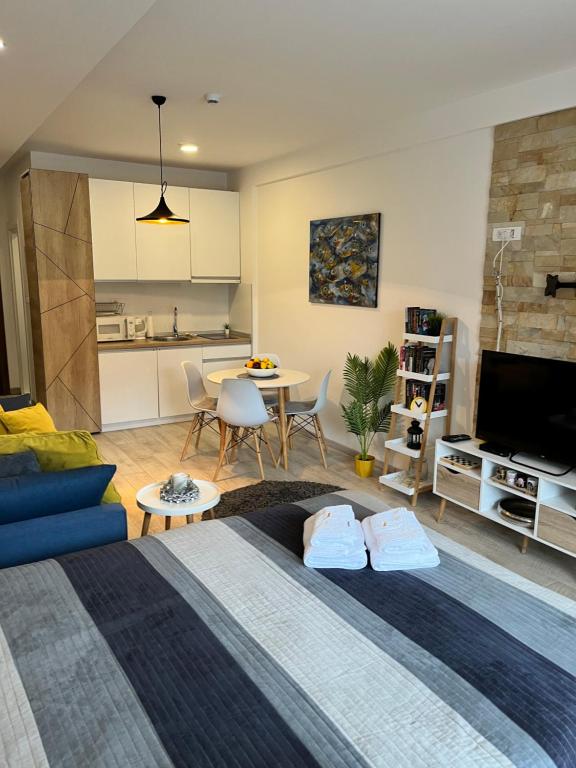 a bedroom with a bed and a living room at Milmari Resort - Apartman L43 in Kopaonik