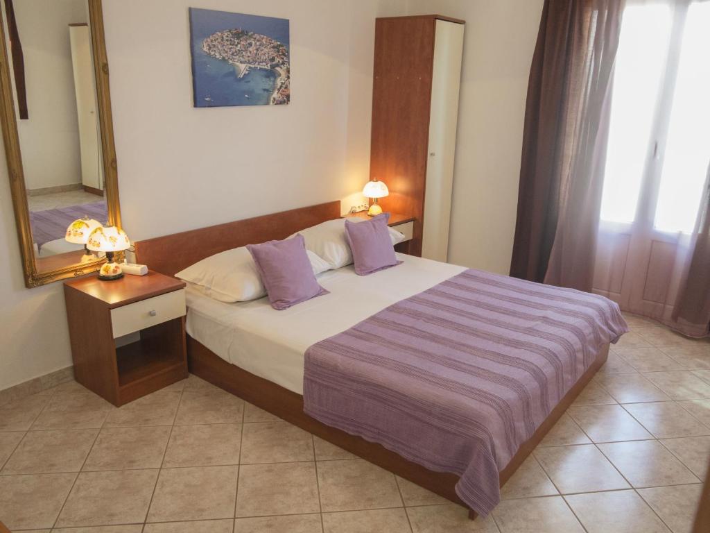 a hotel room with a bed and a mirror at Apartments Jadrijević Brne in Primošten