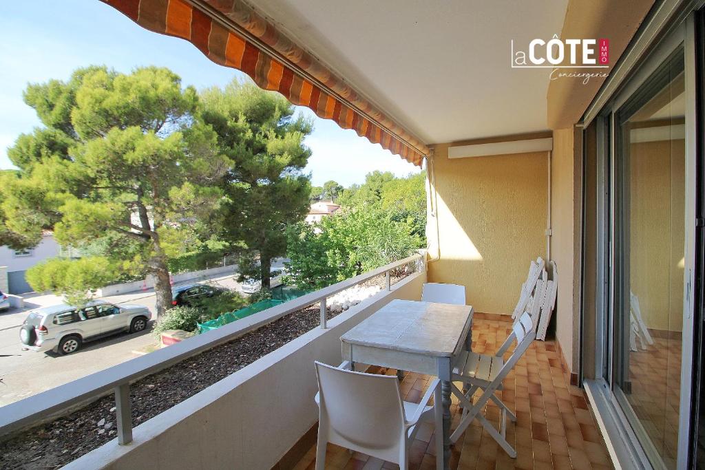 einen Balkon mit einem Tisch und Stühlen sowie Straßenblick in der Unterkunft LE CORVETTE 1 - 4 COUCHAGES in Carry-le-Rouet