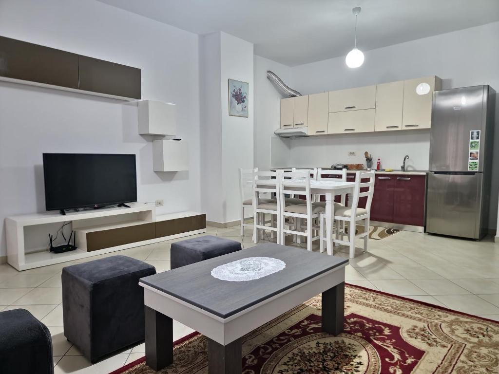 a kitchen and a living room with a table and a kitchen and a kitchen at Siar Apartment in Tirana