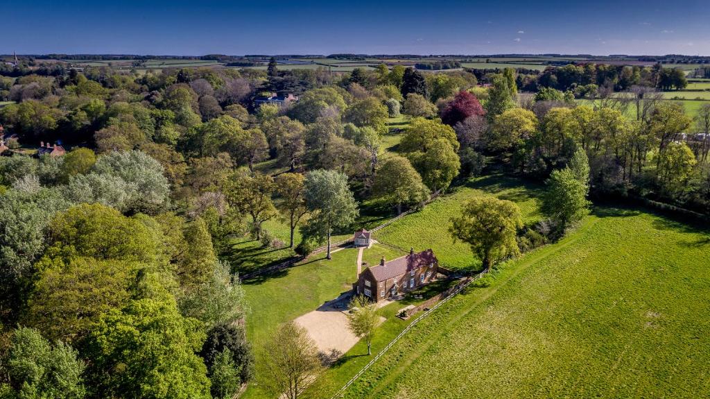 una vista aérea de una casa en un campo con árboles en Rural Coastal Self-Catering Accommodation for 8, Near Sandringham Estate, Norfolk, en Ingoldisthorpe
