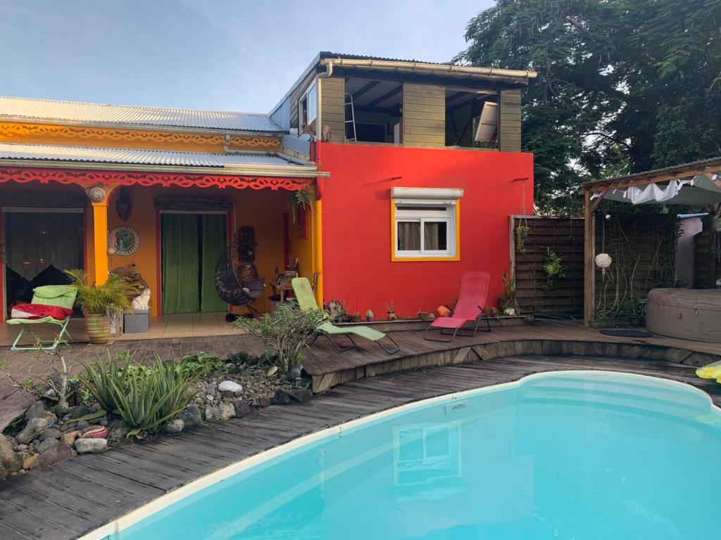 uma casa com piscina em frente a uma casa em Kazamwe em Petit-Bourg