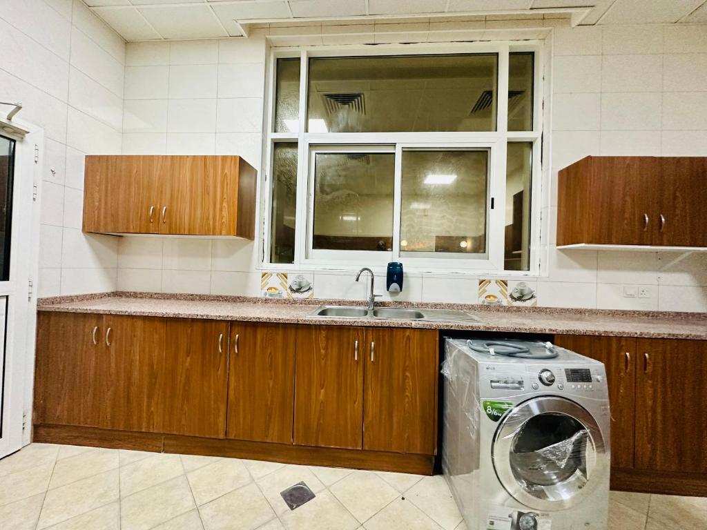 a kitchen with a washing machine and a window at Couple room with attached bathroom in Dubai
