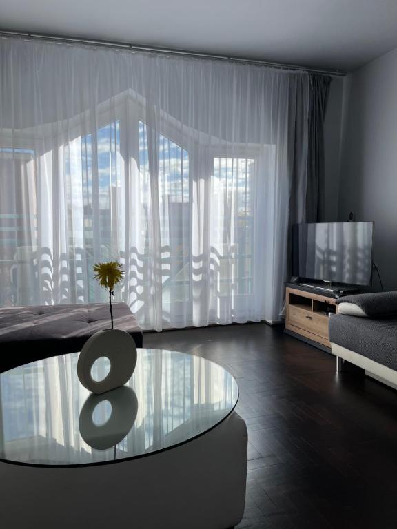 uma sala de estar com uma mesa de vidro e uma televisão em Corporal Apartment Budapest em Budapeste