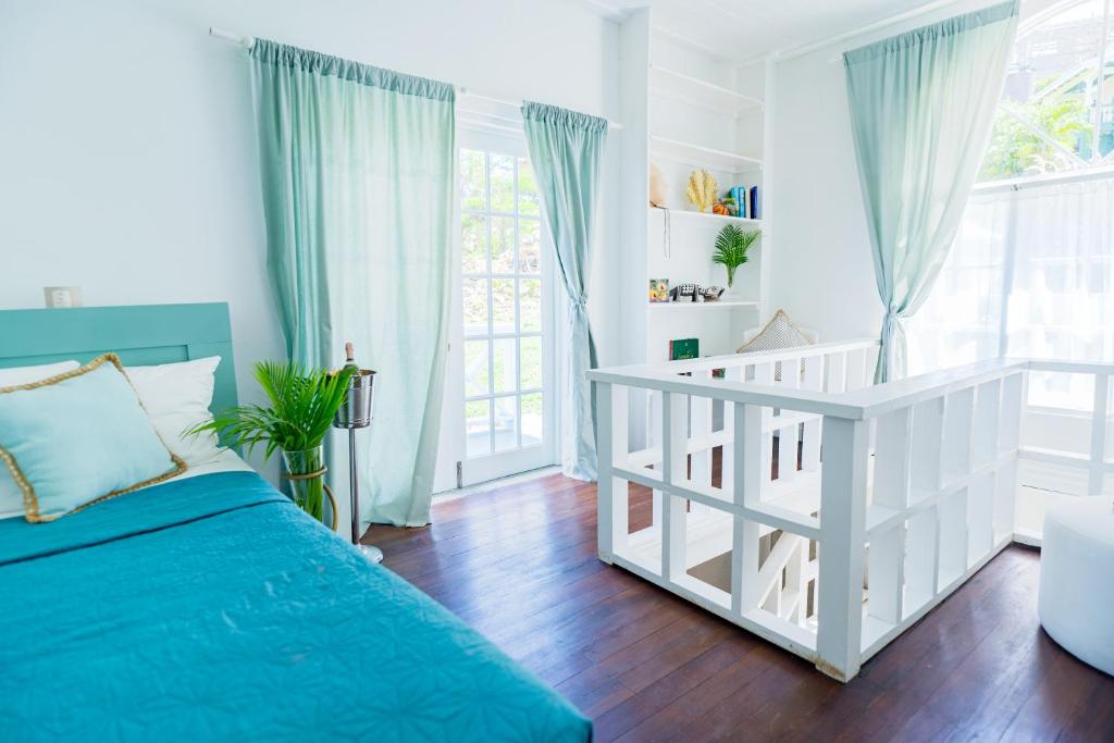 een witte slaapkamer met een bed en een raam bij Bay House Grenada in Belmont
