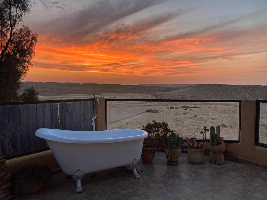 a bath tub sitting on a patio with a sunset at Skyline in Mitzpe Ramon