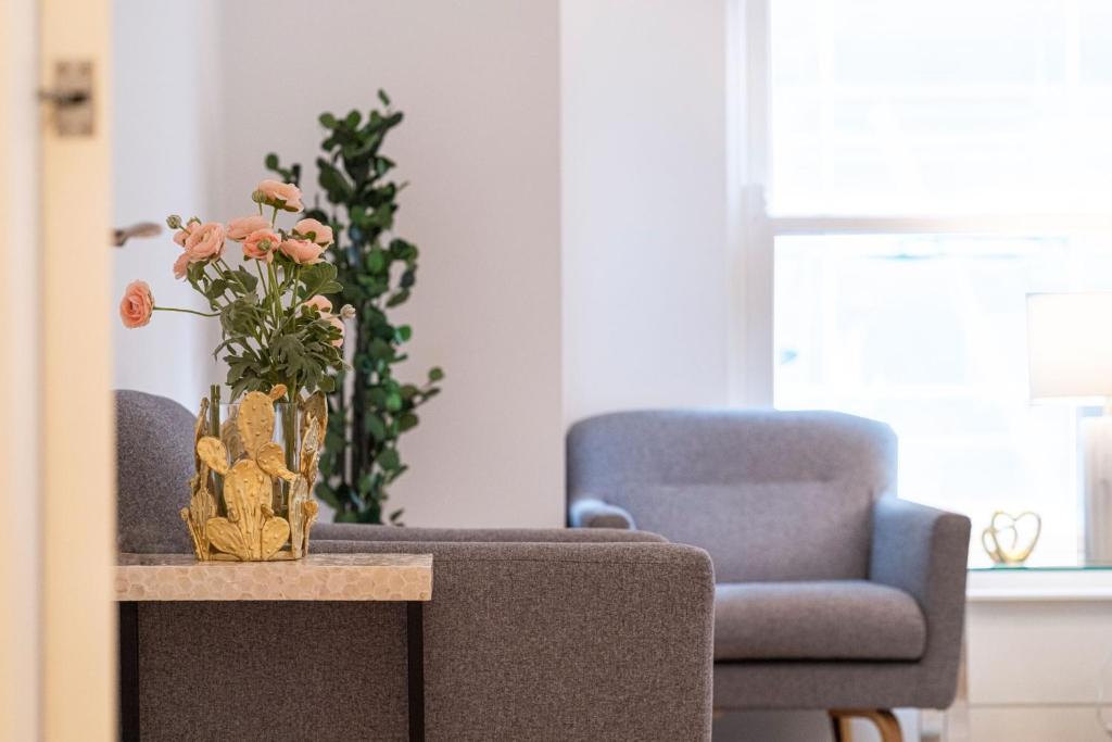 een vaas met bloemen op een tafel in een woonkamer bij London Mayfair W1 in Londen