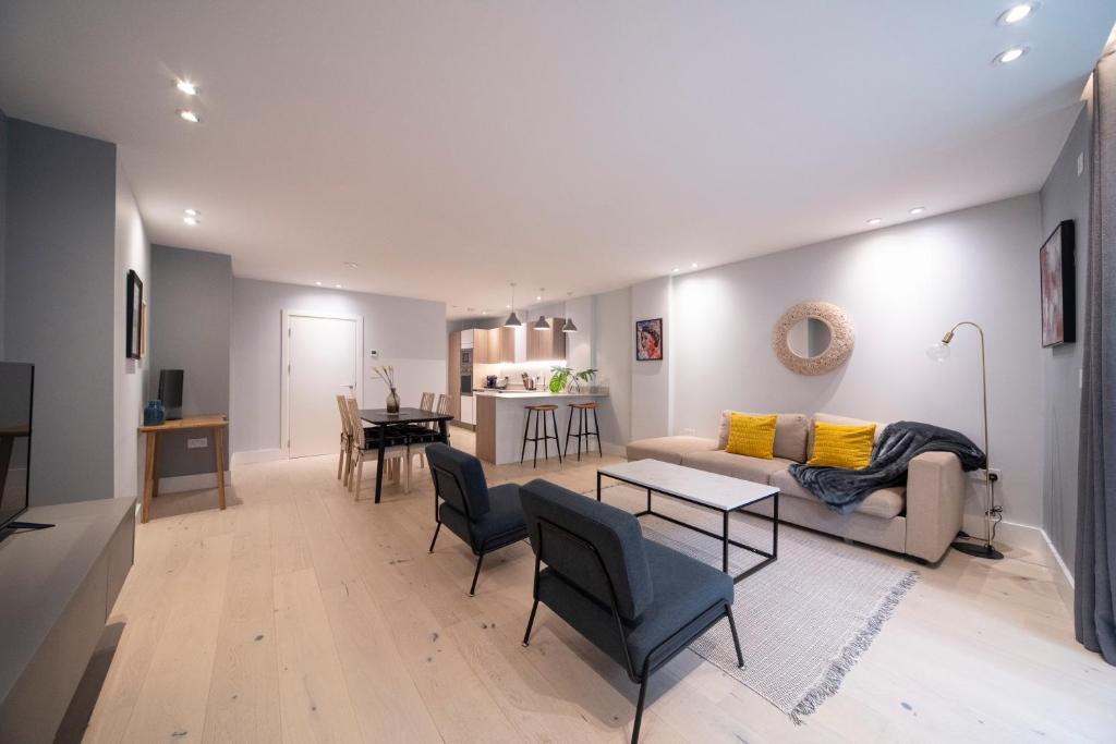 - un salon avec un canapé et une table dans l'établissement Stylish 1BR - Bright & Large Living Area w/ Patio, à Londres