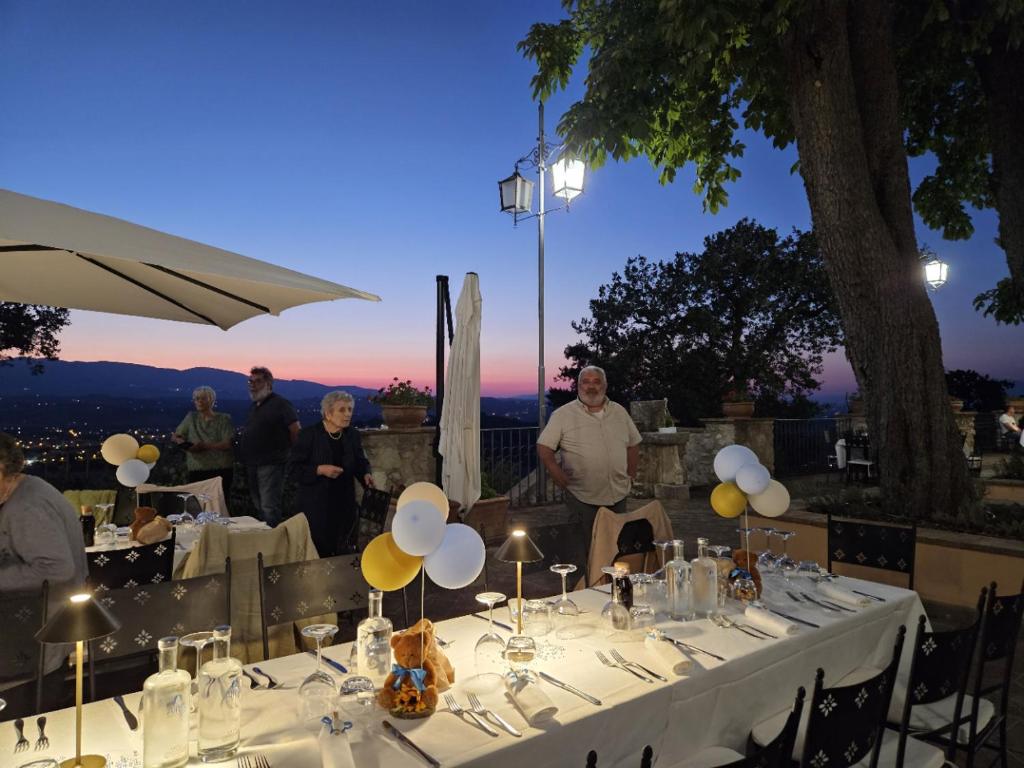grupa ludzi stojących przy stole ze światłami w obiekcie AGRITURISMO Villino Bellavista w mieście Spoleto