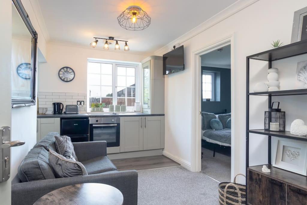 Il comprend un salon avec un canapé et une cuisine. dans l'établissement Blissful 1 bed flat Bedworth, à Bedworth