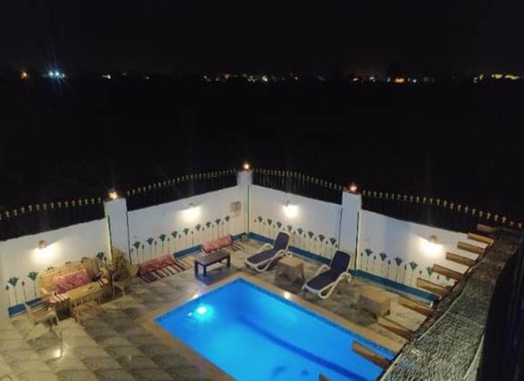 - une piscine au-dessus d'un bâtiment la nuit dans l'établissement Villa Colossi Memnon, à Louxor