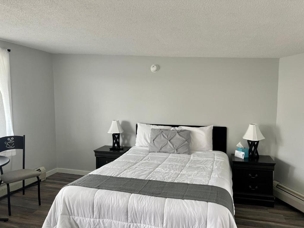 a bedroom with a large bed with two nightstands and two lamps at Lincoln House Motel in Lincoln