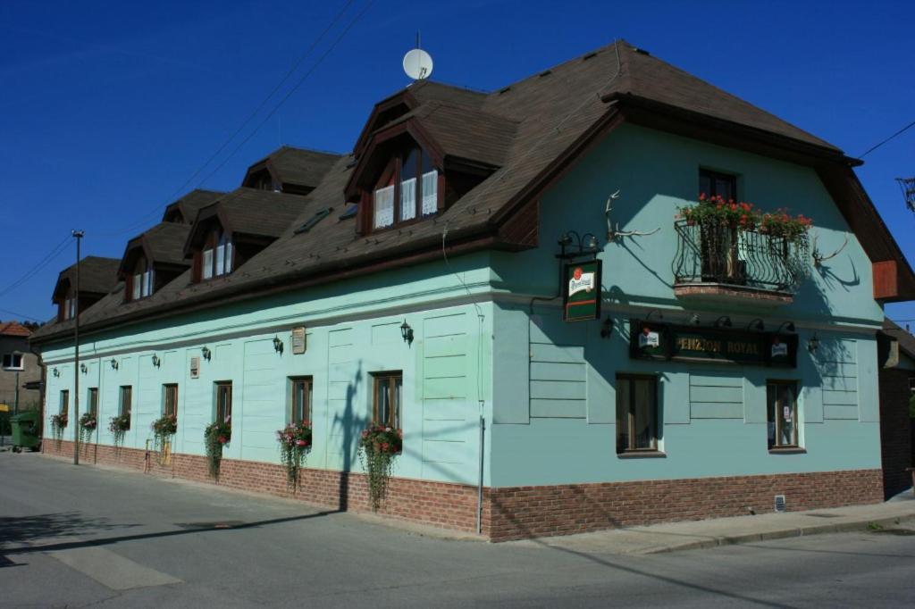 un edificio azul y blanco con techo marrón en Penzión ROYAL en Bytča