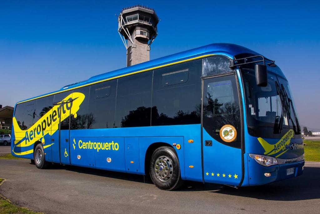 a blue bus parked in front of a control tower at Casa dos Leones in Santiago