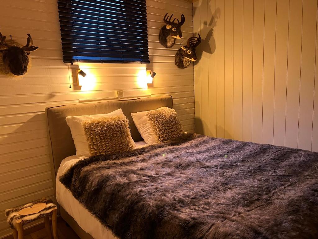 - une chambre avec un lit et une couette violette dans l'établissement Cabane La Folie Douce, à Hotton