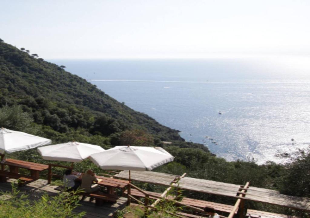 a group of tables with umbrellas on top of a hill at Agririfugio Molini in Camogli
