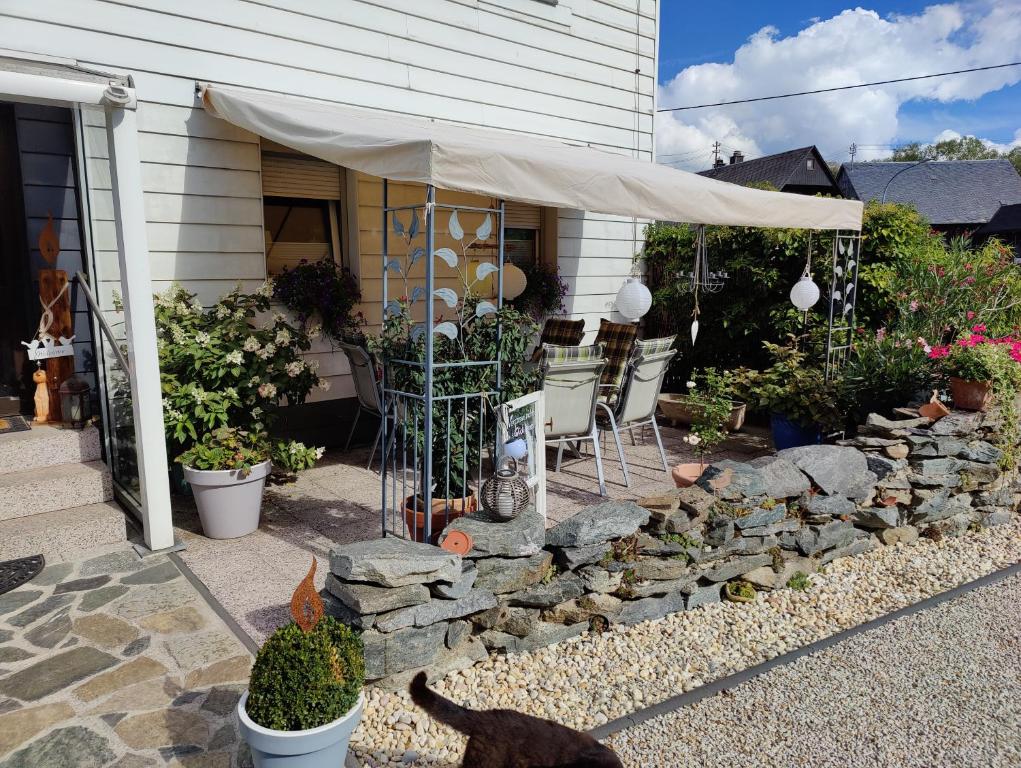 a patio with a stone wall and a tent at Landwohnung Max&Fritz in Schauenstein