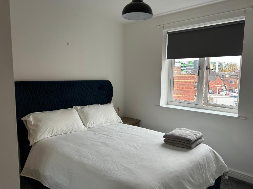a bedroom with a white bed with a window at Stafford 2 Bedroom Apartment in Prime Location with Secure Parking in Stafford