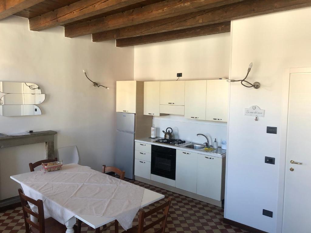 a kitchen with a table and a white refrigerator at Casa Angela Apartments in Bergamo