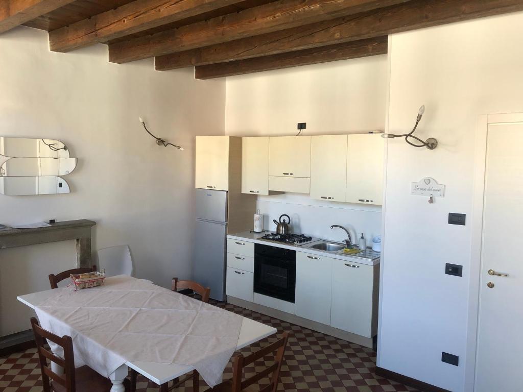 una cucina con un tavolo e un frigorifero bianco di Casa Angela Apartments a Bergamo