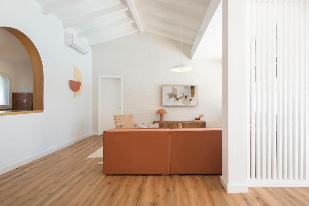 a living room with a wooden floor and white walls at Villa Tropico - Design house with pool in Corralejo in Corralejo