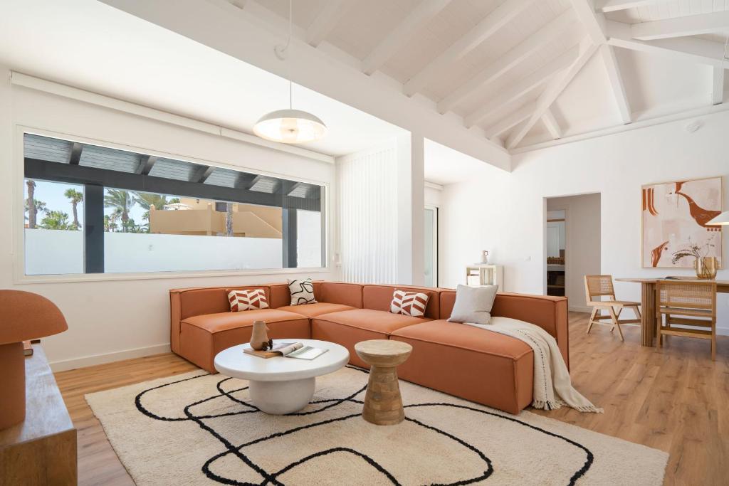 a living room with a couch and a table at Villa Tropico - Design house with pool in Corralejo in Corralejo