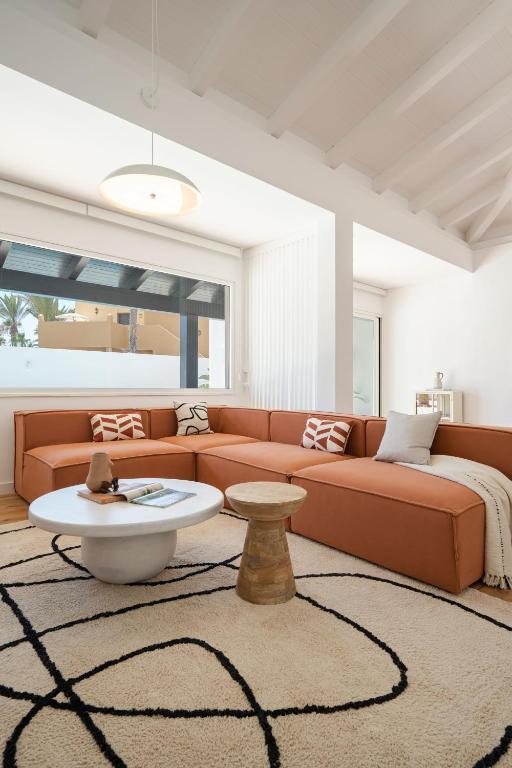 a living room with a couch and a table at Villa Tropico - Design house with pool in Corralejo in Corralejo