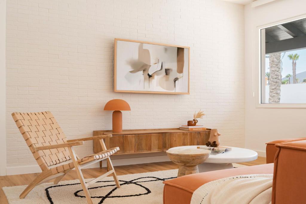 a living room with a chair and a table at Villa Tropico - Design house with pool in Corralejo in Corralejo